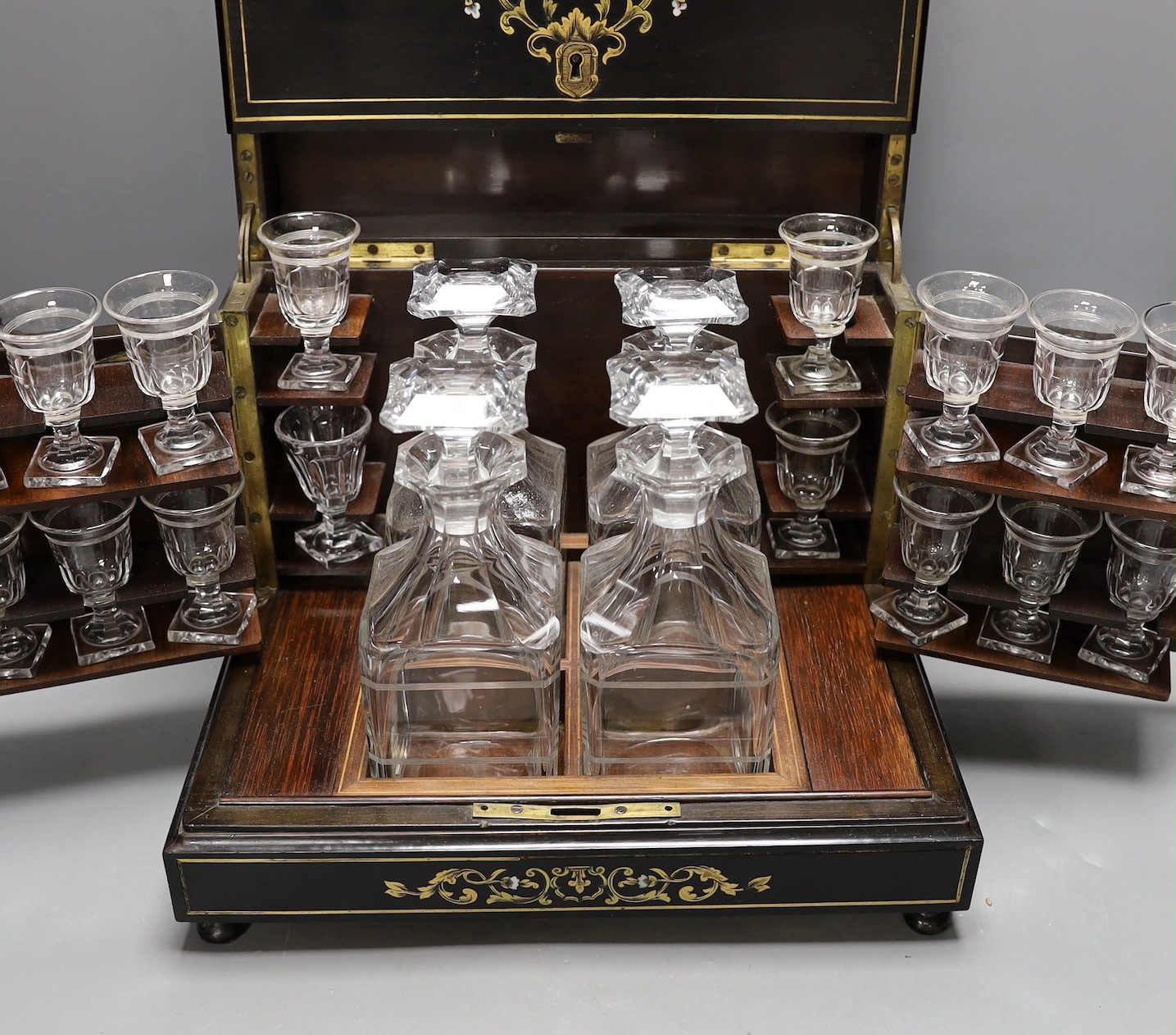 A 19th century mother of pearl and cut brass inlaid liqueur casket, 32cm, containing four original glass decanters and stoppers and 16 liqueur glasses